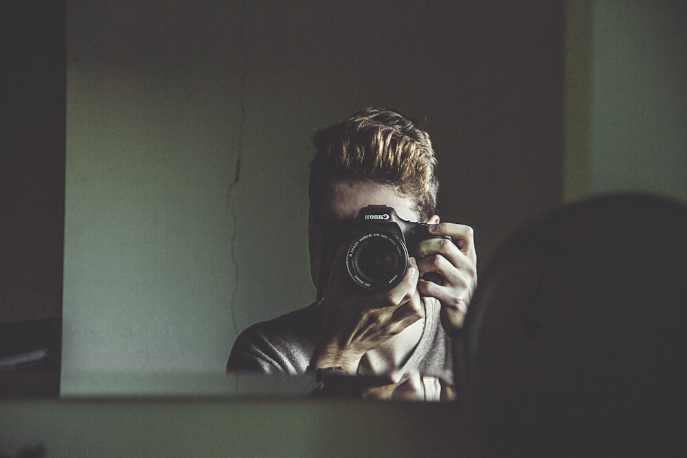 homme prenant une photo sur le miroir