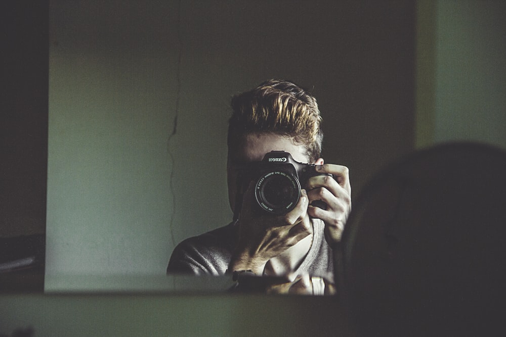 man taking photo on mirror