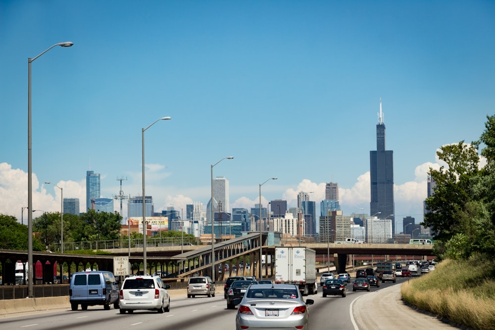 cars on road near city buildings during daytime