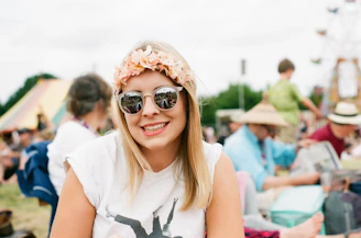 A smiling fan wearing a colorful ixa werika hoodie at an outdoor concert.