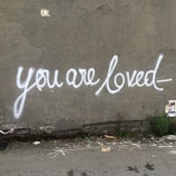 A close-up of a handwritten note saying ‘You are loved.’