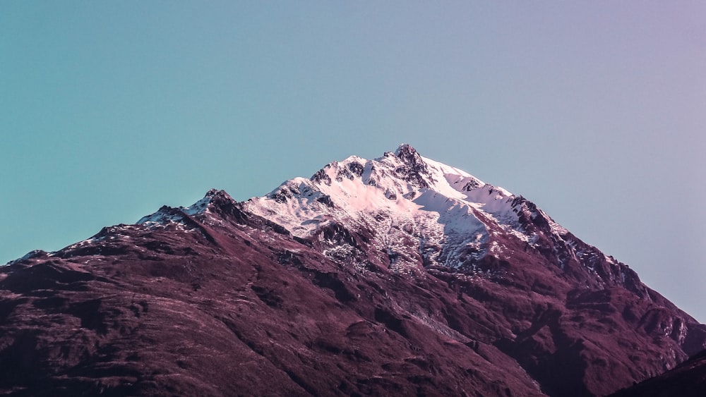 mountain with snow cap under gray clouds at daytime