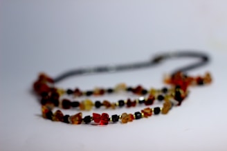 A bohemian-style necklace with earth-toned stones displayed on natural linen fabric.