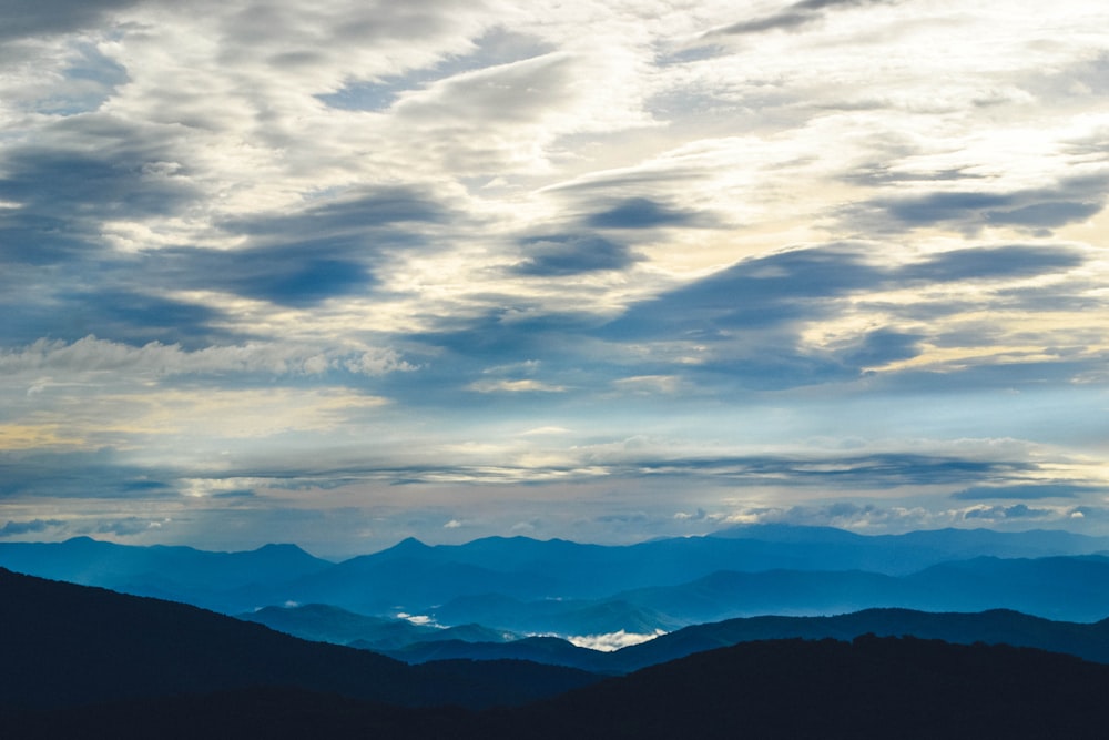 silhouette of mountains under sea clouds