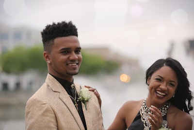 selective focus photography of man taking photo beside woman prom zoom background