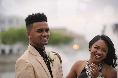 selective focus photography of man taking photo beside woman prom teams background