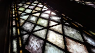 Detailed view of geometric stained glass shapes in shades of blue and green.