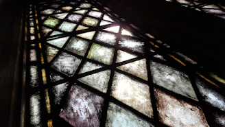 Detailed view of geometric stained glass shapes in shades of blue and green.