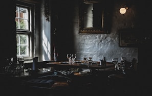 Warmly lit dining area with rustic wooden tables and soft candlelight