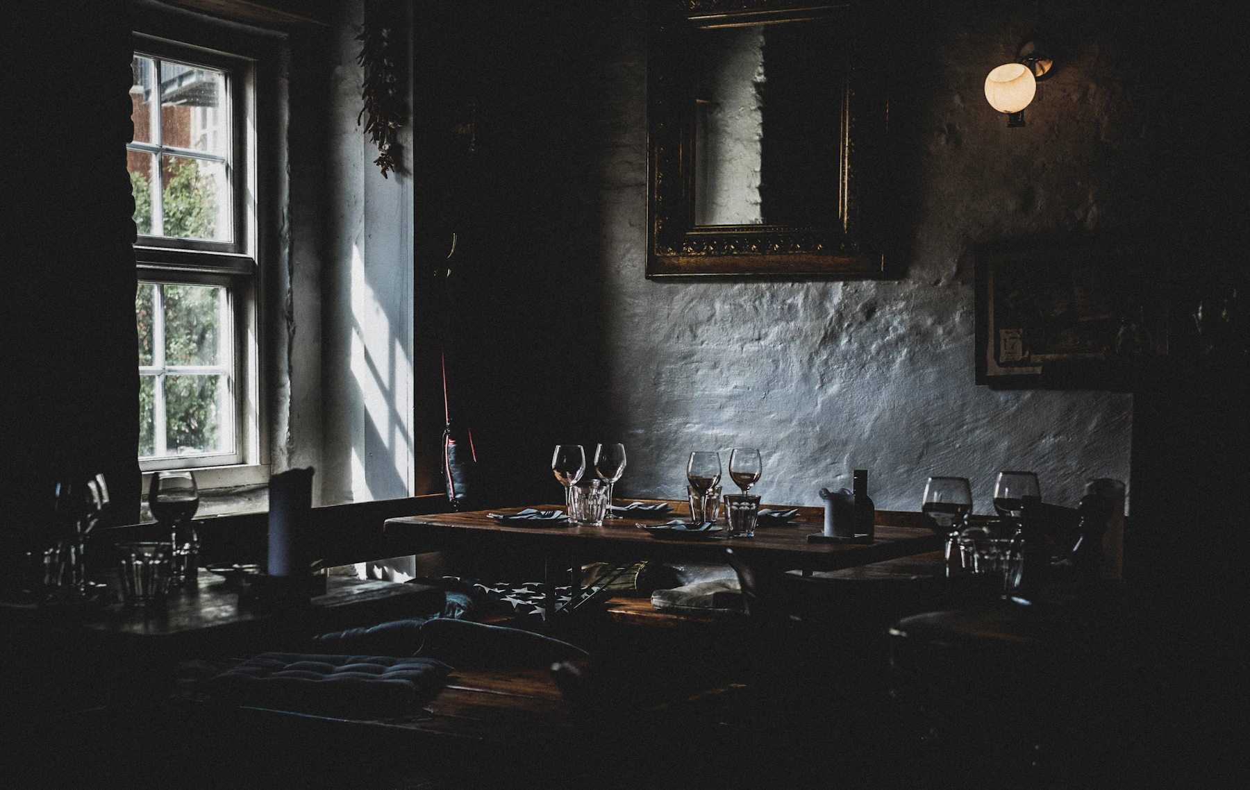 A dimly lit dining room with candlelit tables