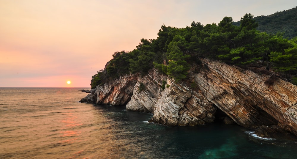 brown rock formation near body of water