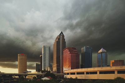 wide angle photo of buildings under cumulus clouds