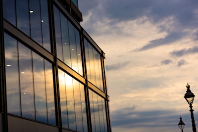 Contemporary commercial building with reflective glass and gold detailing at sunset.