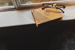 Sunlight streaming through a window onto a journal and a pair of running shoes.