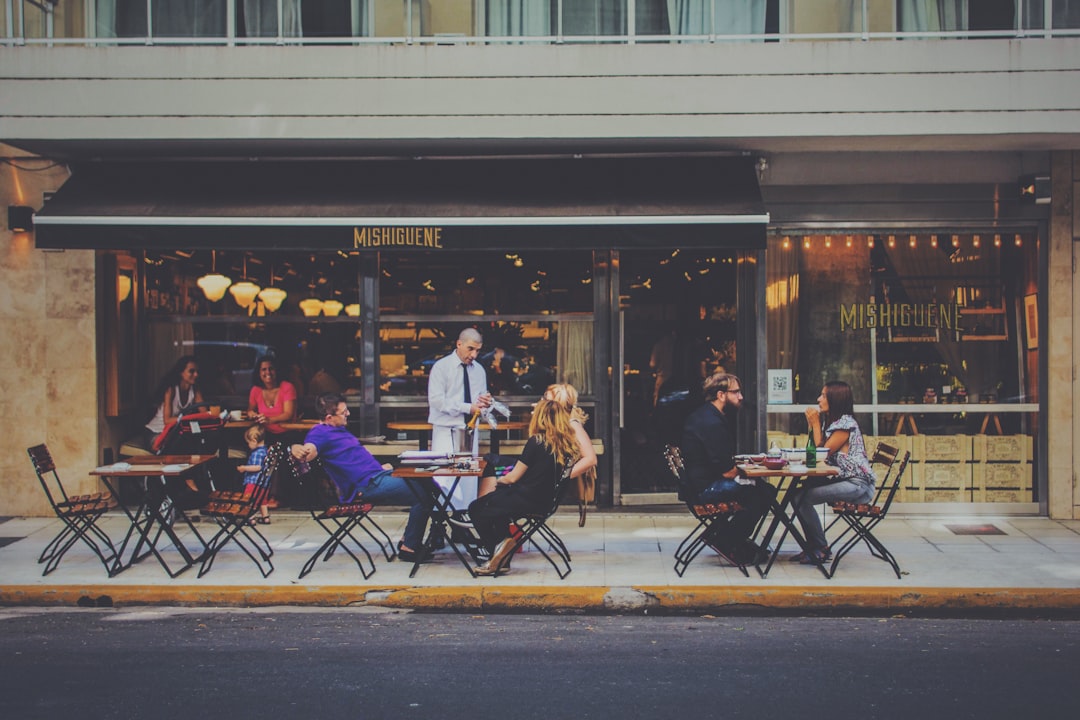 people sitting on chairs in front of facade, Outdoor Cafe