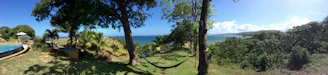 A cozy beachfront rental property with a hammock and palm trees swaying gently.