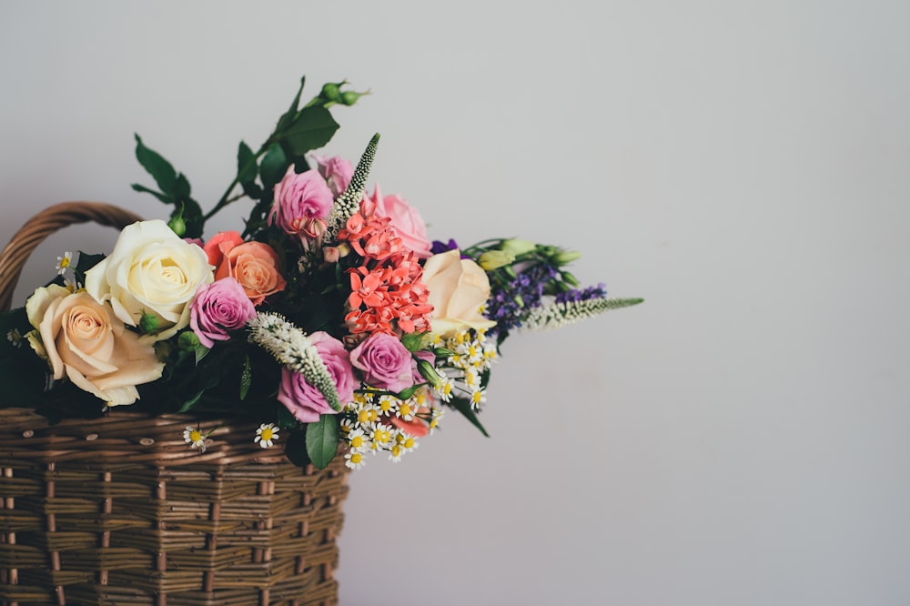 flores de colores variados en cesta de mimbre marrón