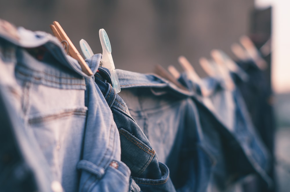 selective focus photo of blue denim jeans hanged