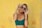 woman in blue bralette holding sunglasses putting on her eyes