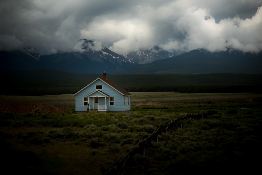 灰色の空の下の草原の家