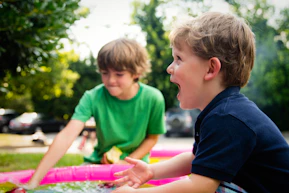 boy in blue shirt screaming near boy in green crew-neck shirt