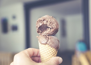 selective focus photography of chocolate ice cream on brown cone