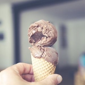 selective focus photography of chocolate ice cream on brown cone