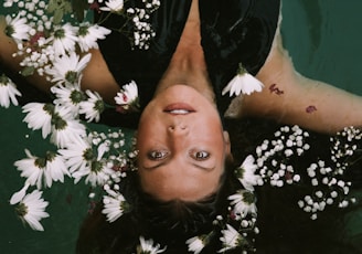 woman swimming covered by white daisies