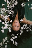 woman swimming covered by white daisies