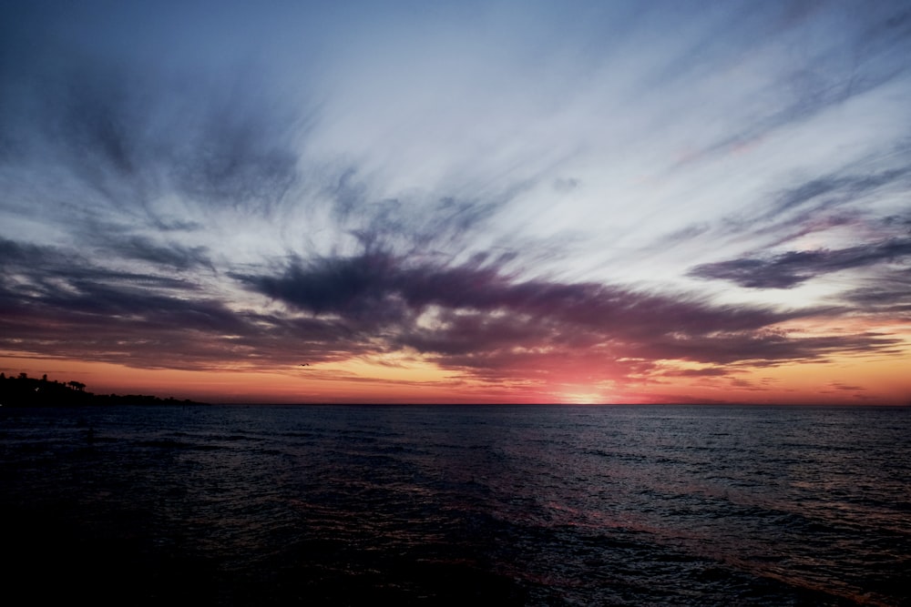 Oceano sob o céu sombrio durante a hora dourada