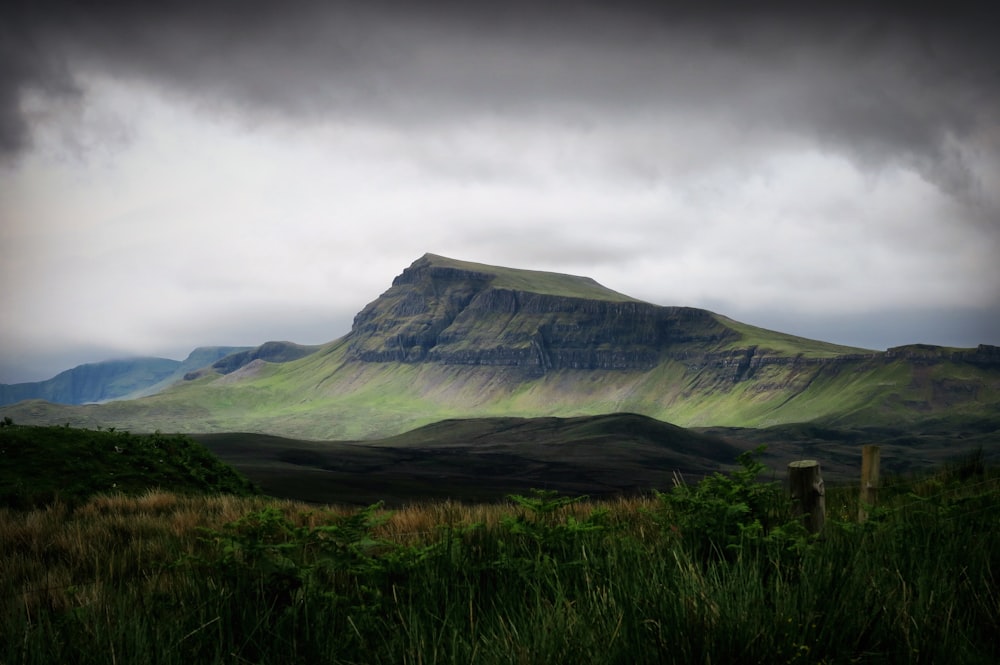 green mountain under cloudy sky ]