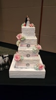 A beautifully decorated wedding cake with blue and white icing details.