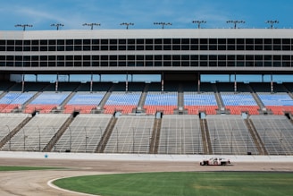 aerial photography of car on stadium under clear blue sky