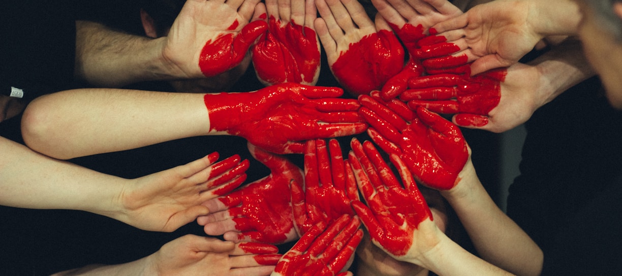 hands formed together with red heart paint