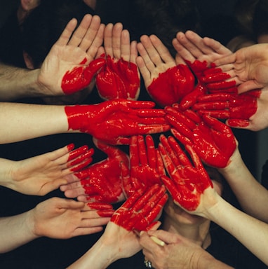 hands formed together with red heart paint