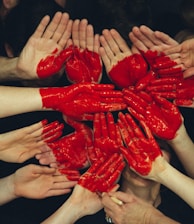 hands formed together with red heart paint