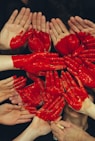 hands formed together with red heart paint