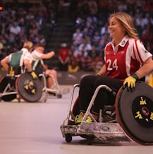 focus photo of woman in red and white polo shirt with black pants in ice wheelchair
