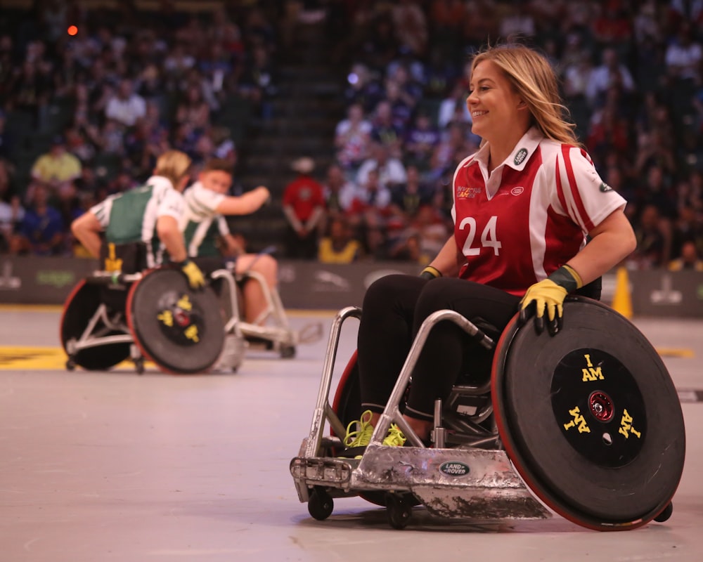 focus photo of woman in red and white polo shirt with black pants in ice wheelchair