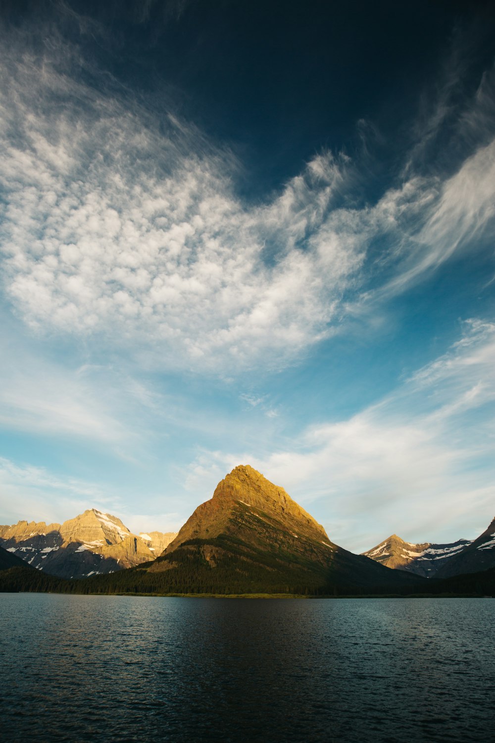 photographie de paysage de montagnes à côté d’un plan d’eau
