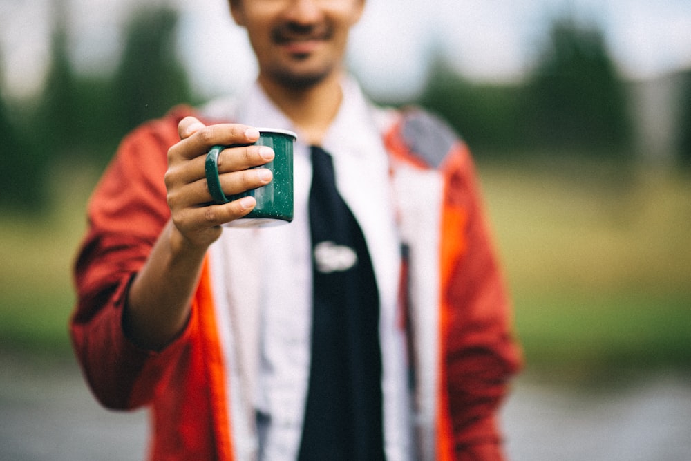person holding mug in shallow focus