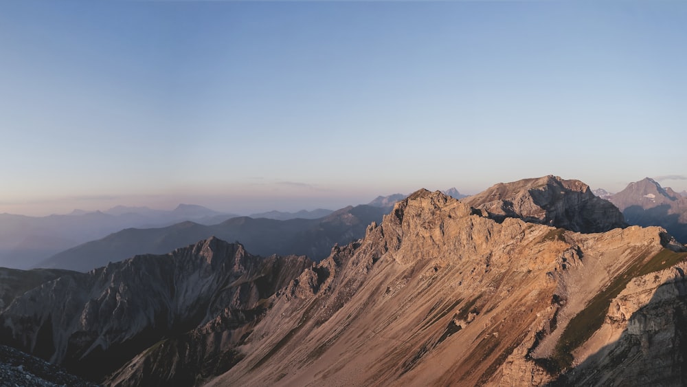 Photographie de paysage de la chaîne de montagnes brunes sous le ciel bleu pendant la journée