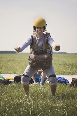 Close-up of a smiling adventurer wearing a helmet and harness, ready for action.