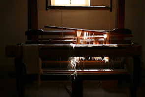 Rows of traditional wooden looms in the Bhadohi workshop bathed in soft natural light.