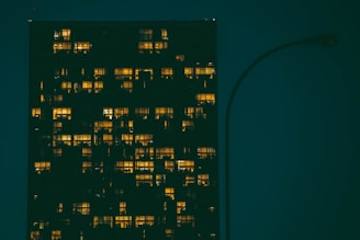 Evening view of a high-rise building with lights glowing in the windows.