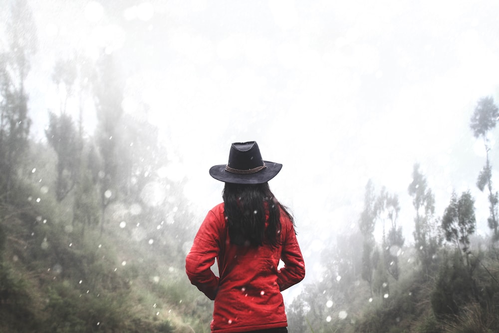 woman in red shirt standing near forest