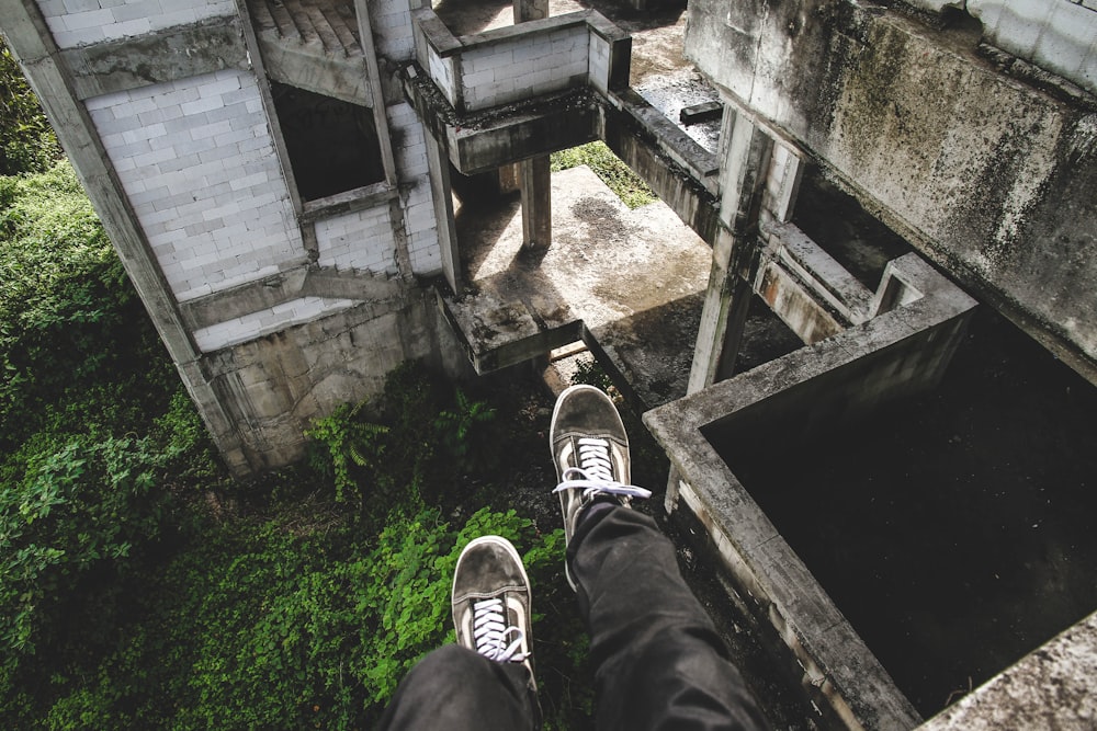 Persona sentada en un edificio abandonado gris
