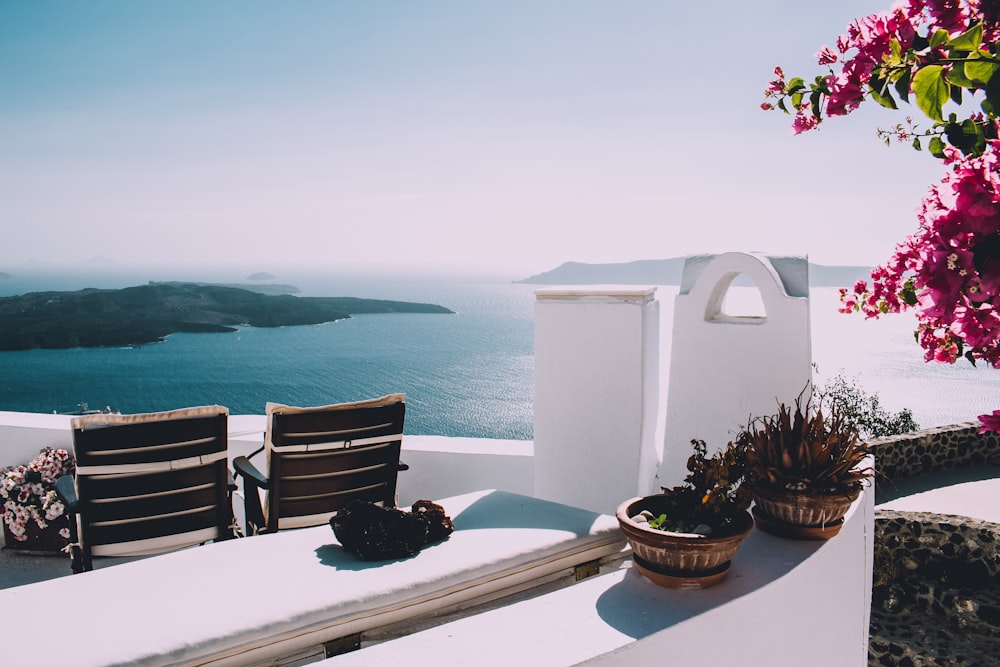 two brown wooden chairs beside the wall