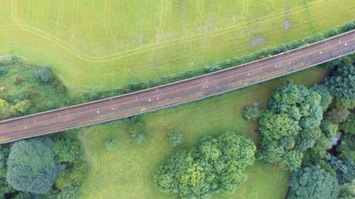Engineers inspecting a newly built railway track surrounded by lush greenery.