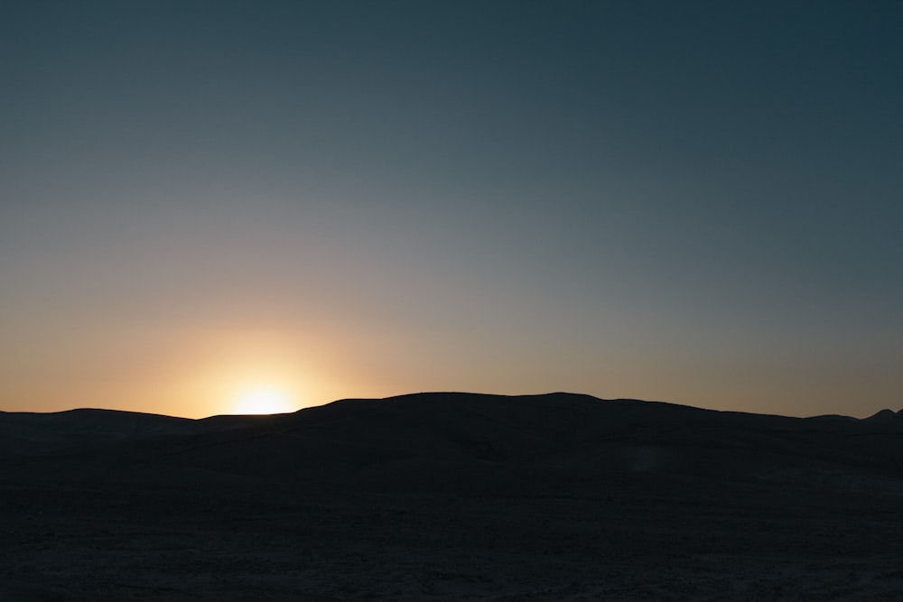 silhouette of mountain during golden sky